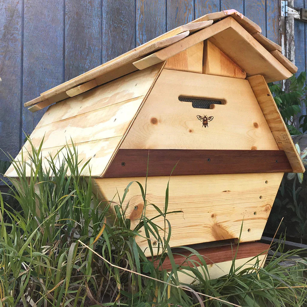 A beehive sitting among long grass