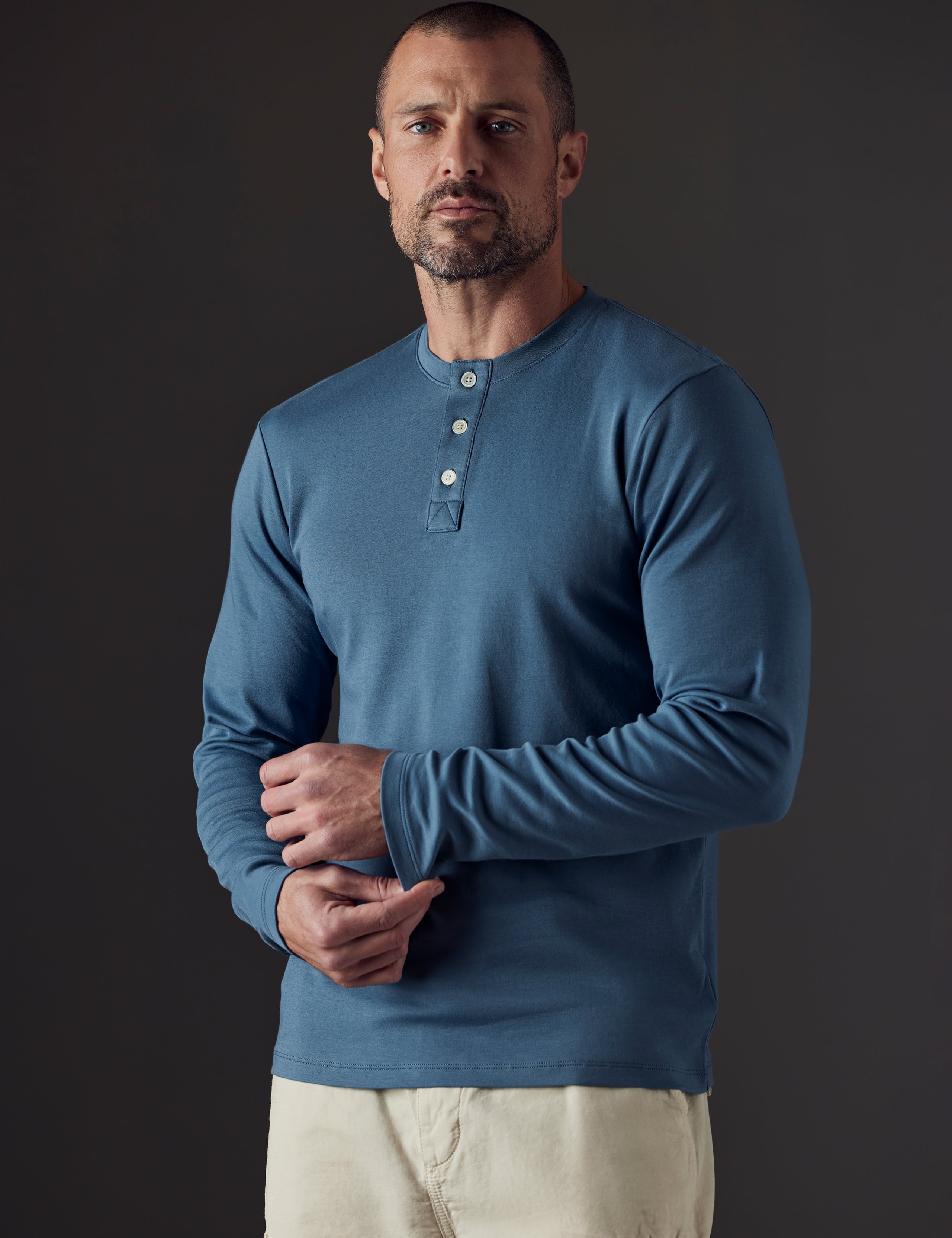Front 3/4 body view of man wearing Emery Pima Henley in Coastal Blue from AETHER Apparel.