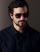 Front right 3/4 view of man wearing Bryce Sunglass in Brushed Silver titanium with Grey Lens from AETHER Apparel.