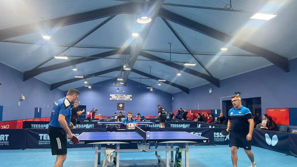 men playing table tennis in a sports hall