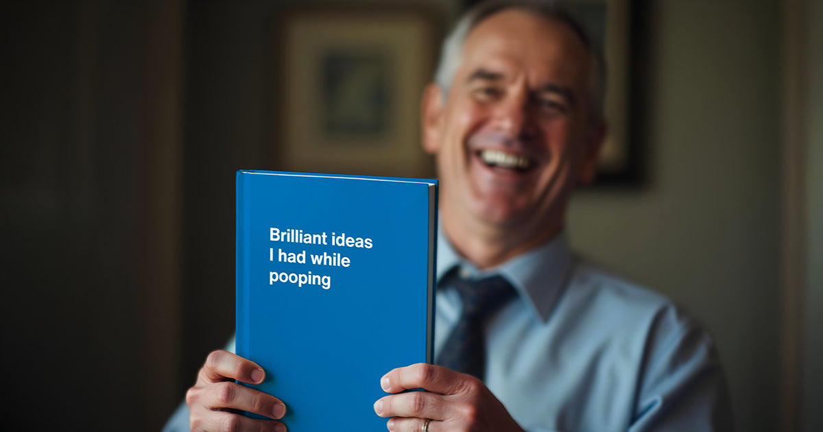 A middle-aged man holding his funny Father's Day gift – a WTF Notebook entitled