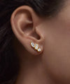 Close-up of a woman's ear adorned with Lab Grown Sapphire Climber Studs featuring mixed lab-grown sapphires in round, marquise, and baguette cuts.