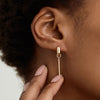 Person touching an earring with a Single Bar Hoop Charm, showcasing a sleek, rectangular design perfect for personalizing everyday hoops with interchangeable charms.