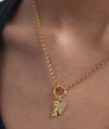 Expression Charm necklace featuring a close-up of a heart-shaped pendant on a gold chain, elegantly worn around a woman's neck.