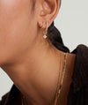 Cluster Pearl Hoop Charm on a woman's ear, showcasing handcrafted 14k gold hoops adorned with multiple freshwater pearls for a customizable look.