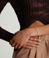 Close-up of a woman's hands showcasing a delicate Tiny Pearl Bracelet, highlighting its elegant design and subtle charm.