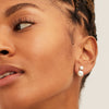 Close-up of a woman's face showcasing Essential Pearl Earrings, handcrafted in 14k solid gold with three finishes, highlighting elegance and sophistication.