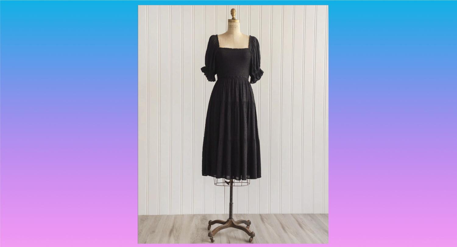 Um vestido preto com busto franzido e mangas bufantes em um manequim vintage de juta.