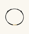 Bar Cord Bracelet featuring a sleek black cord with a polished gold bar, designed as a stylish, signature fashion accessory.