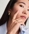 Woman showcasing the Beaded Ring on her finger, highlighting its 14k white gold and rhodium-plated finish. The ring is durable and 1.3 mm thick.