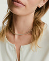 Zadie Bezel Lab Grown Sapphire Tennis Necklace elegantly adorns a woman's neck, showcasing its sleek bezel setting and brilliant shine.
