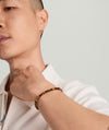 Man wearing a 4mm Gemstone Beaded Bracelet with sterling silver beads and a swivel clasp. Close-up highlights the bracelet's texture and craftsmanship.