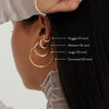 Close-up of a woman wearing Tube Huggie Hoops, showcasing modern, lightweight gold hoops with a secure clicker closure.