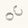 Bold Huggie Hoops: A pair of silver hoop earrings, known for their sleek design and versatility, perfect for elevating any outfit.
