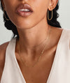 Woman wearing Boyfriend Bold Chain Necklace and gold hoop earrings. Close-up highlights the necklace's raw, bold design, complementing her white shirt.