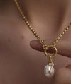 Person wearing a Diamond Number Charm necklace featuring a gold chain with a diamond-studded number pendant, showcasing elegance and luxury in a close-up view.