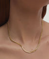 Person wearing a Flat Curb Chain Necklace, showcasing the gold chain's elegant design and its versatility as a fashion accessory.