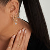 Close-up of a woman wearing a Single Gemstone Cluster Hoop Charm on her ear, hand on neck, showcasing the charm's elegance.