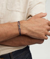Person wearing the Linked Cord Bracelet, showcasing handcrafted cords with sterling silver links on their wrist.