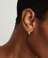 Close-up of a woman's ear wearing Bold Huggie Hoops, showcasing the elegant, outfit-enhancing design of these popular earrings.