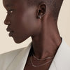 Woman in a white suit wearing the Boyfriend Bold Chain Necklace, a raw and loose silver necklace, highlighting her short hair and matching earrings.