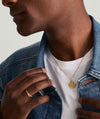 Man wearing a denim jacket and the Boyfriend Bold Chain Necklace featuring a gold pendant with a snake in the middle.